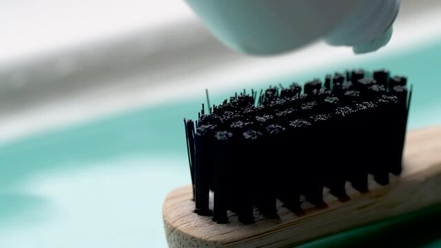 blue toothpaste squeezed onto eco-friendly organic bamboo toothbrush