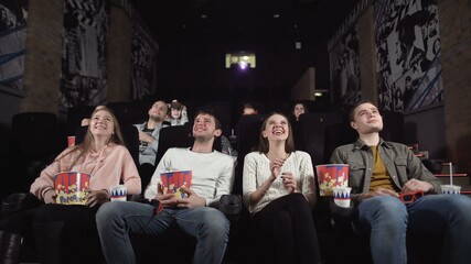 Young people laugh at comedy movie in cinema theatre. Young people laughing at cinema watching amusing comedy.