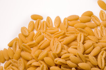 Sardinian gnocchi Italian dry raw pasta bronze drawn white background  top view