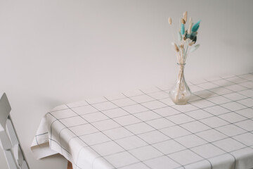 Bouquet of dried flowers in a vase at home interior. Floral composition on the table with tablecloth. 