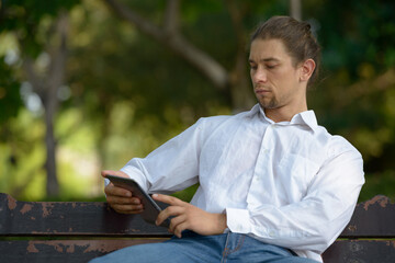 Obraz premium Handsome bearded businessman with long hair at the park