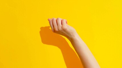 Top view of a fist of a woman on a yellow background