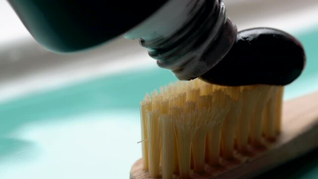blue toothpaste squeezed onto eco-friendly organic bamboo toothbrush