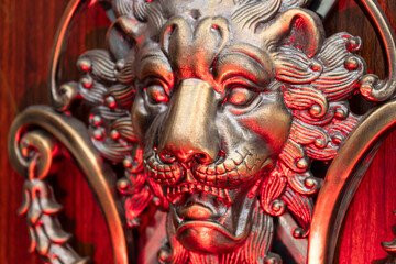 Fototapeta premium Close up to a golden Iron Lion shiled iluminated with red light. Interior design, ornaments and welding concept
