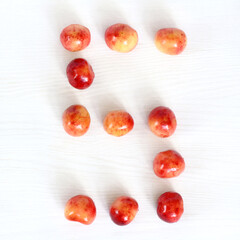 Fototapeta na wymiar number five from berries of sweet cherry on light surface, top view. sweet countdown 5