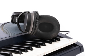 closeup of headphones lying on the keyboard of an electronic piano