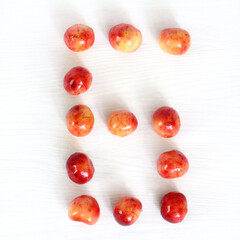 Fototapeta na wymiar number six from berries of sweet cherry on light surface, top view. sweet countdown 6