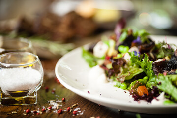 Fresh vegan salad. Avocado, couscous, melon, portobello, soybean, tofu on white plate. Delicious healthy mixed greens food closeup served on a table for lunch in modern cuisine gourmet restaurant.