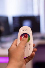 Remote control in a woman's hand with red manicure. Remote control for LED lighting. close-up,...