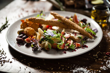 Cheese platter for two: Goat cheese cream, gorgonzola, camembert, grissini and fig jam. Delicious healthy Italian traditional food closeup served for lunch in modern gourmet cuisine restaurant
