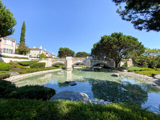 Public Park with green garden and landscape design with water pond and small water stream surrounded by villa in La Jolla, California. USA