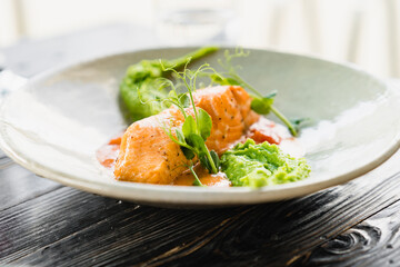 Salmon with green pea cream close up