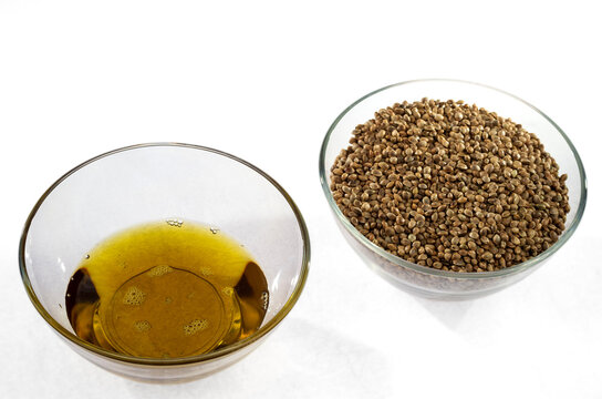 Hemp seeds and hempseed oil in glass bowls isolated on a white background.