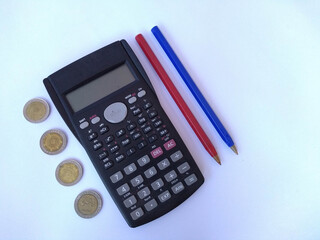 Calculator coins and pens on white background