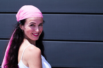 Young girl posing with a pink scarf fighting breast cancer