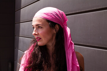 Young girl posing with a pink scarf fighting breast cancer
