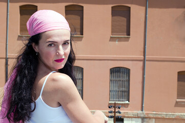 Young girl posing with a pink scarf fighting breast cancer