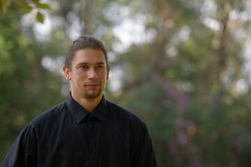 Handsome bearded businessman with long hair at the park