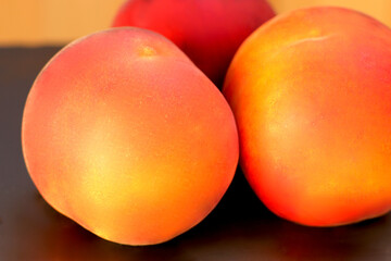Ripe peach fruit, three  peaches (Prunus persica) close-up on black background