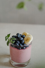 Fototapeta na wymiar Sweet italian panna cotta with blueberry, mint and banana. Fresh tasty breakfast with ripe berries