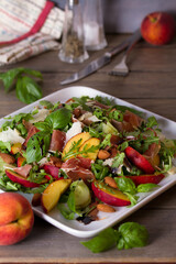 Peach and cured ham salad with cheese, basil, arugula and cucumbers