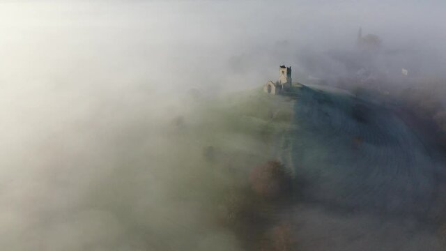 Aerial of the ruins of St. Michaels Church on Burrow Mump surrounded by mist, Burrowbridge, Somerset, England, United Kingdom