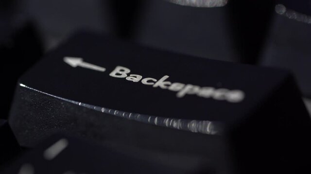 Macro view of Human finger pressing a Backspace key on the computer keyboard