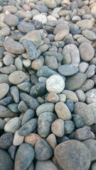 Background of Rounded gray stones on the beach by the sea.