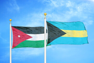 Jordan and Bahamas  two flags on flagpoles and blue cloudy sky