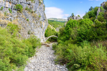 Fototapeta na wymiar Lazaridis Bridge one of the most famous stone arch bridges in the Zagori region it located in the gorge of river Vikos very near to Koukouli village and was built in 1753