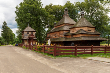 Old (built in year 1586) wooden church architecture by village road.  Gorajec village, Poland, Europe.
