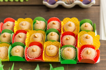 Doces, decorados em pratos sobre mesa decorada para festa.