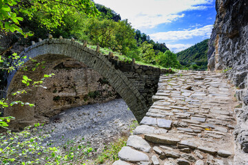 Fototapeta na wymiar Lazaridis Bridge one of the most famous stone arch bridges in the Zagori region it located in the gorge of river Vikos very near to Koukouli village and was built in 1753