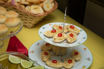 Salgados e pães em mesa de evento.