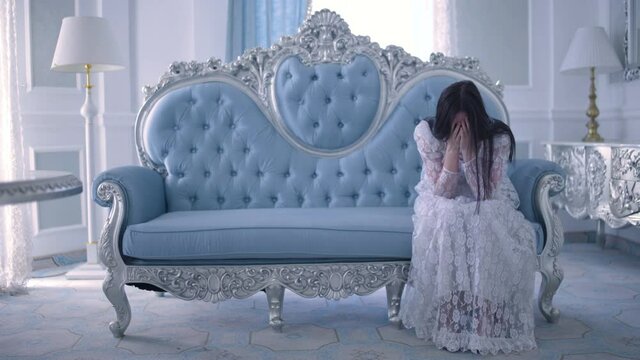 Sad princess crying on sofa, feeling lonely, depressed woman waiting for prince