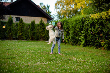Little girl with a puppy in the garden