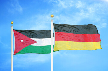 Jordan and Germany two flags on flagpoles and blue cloudy sky
