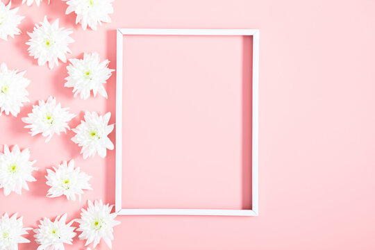 Beautiful flowers composition. Photo frame, white flowers on pastel pink background. Valentines Day, Happy Women's Day. Flat lay, top view, copy space