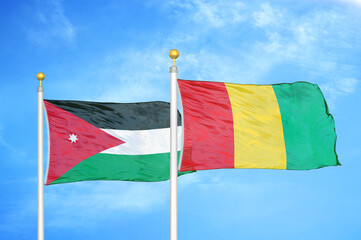 Jordan and Guinea two flags on flagpoles and blue cloudy sky