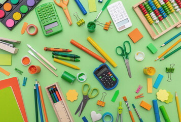 School supplies on green color background, top view