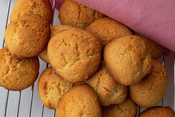 Composition in warm artificial light. Tall lemon bottle, homemade French meringue with chocolate, chicken eggs. On a checkered kitchen towel