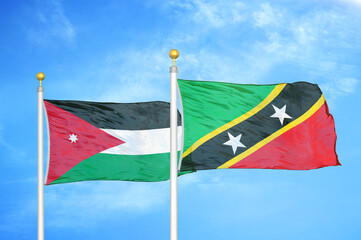 Jordan and Saint Kitts and Nevis two flags on flagpoles and blue cloudy sky