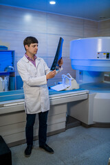 Doctor holding a picture of a brain MRI workflow in diagnostic hospital. Healthcare, roentgen, people and medicine concept.