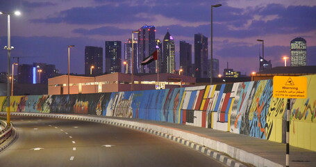 Nächtlicher Highway in Dubai mit Wolkenkratzern im Hintergrund