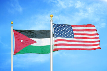 Jordan and United States two flags on flagpoles and blue cloudy sky