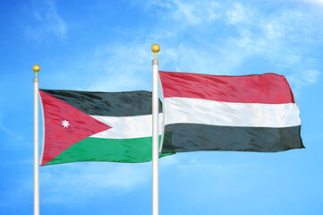 Jordan and Yemen two flags on flagpoles and blue cloudy sky