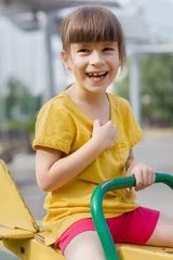 Foto op Canvas Gelukkig meisje op een wip op een speelplaats © Albert Ziganshin