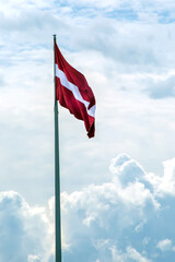 Flag of Latvia against the sky. Red-white flag. - 368103687
