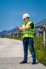 Fototapeta na wymiar Engineer is checking installed solar panels at solar energy plant.