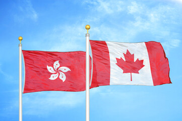 Hong Kong and Canada  two flags on flagpoles and blue cloudy sky